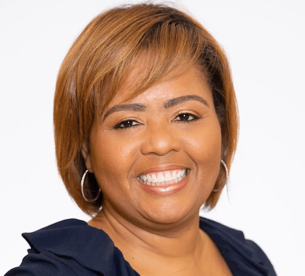 smiling Black woman with short, straight auburn hair and hoop earings in professional headshot
